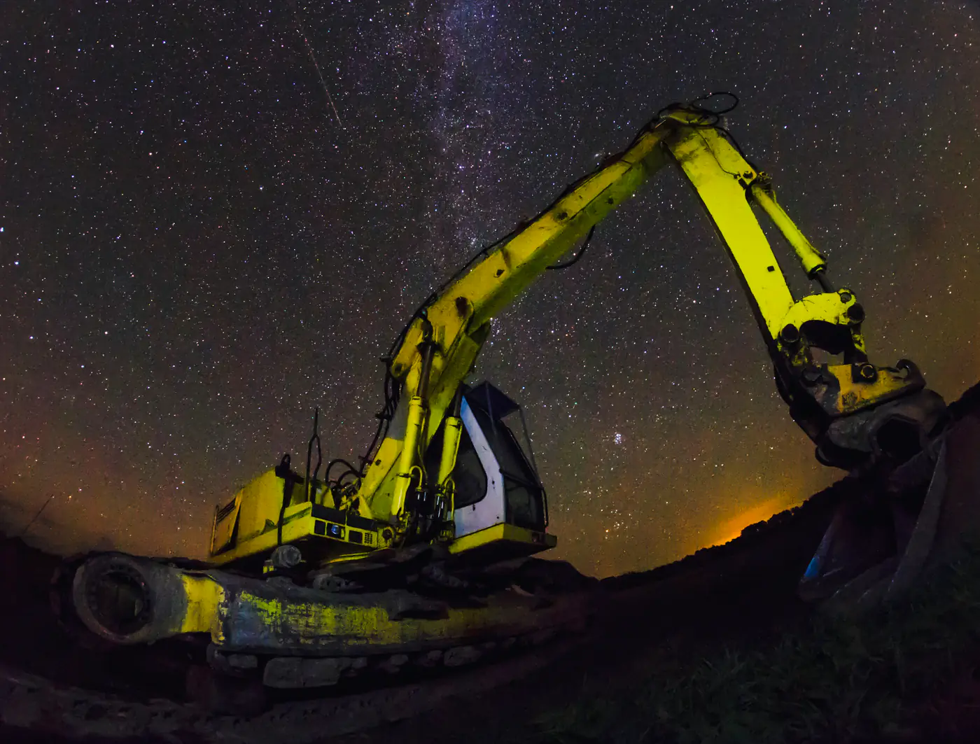 Heavy mining machinery under a night sky